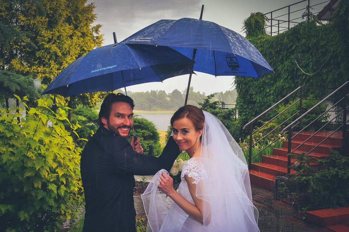 młoda para pod parasolami uciekająca przed deszczem